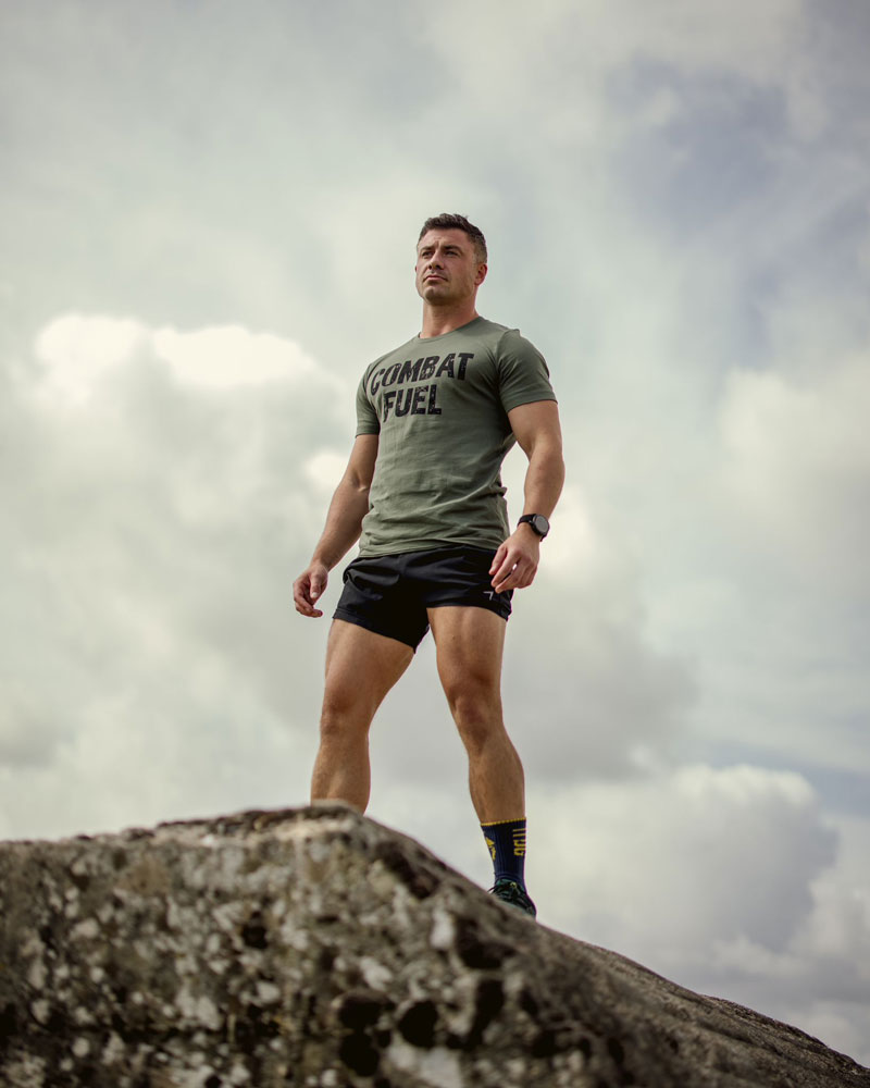 A picture of the coach standing on a rock